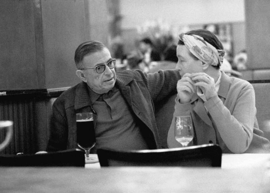 Jean-Paul Sartre (left) and Simone De Beauvoir at la Coupole in Paris, 1969, as photographed by French photographer Bruno Barbey.